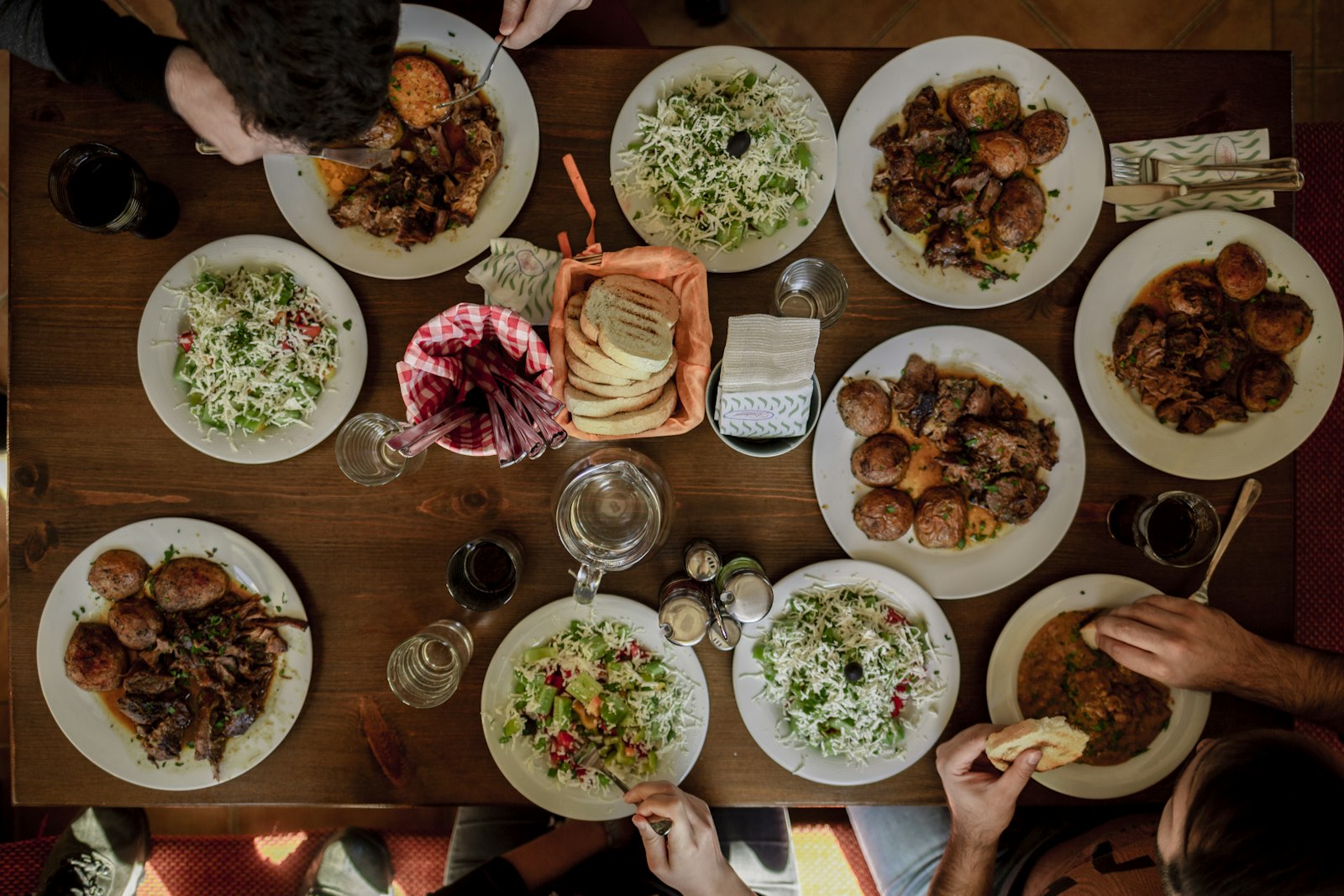 A dinner table set with plates of assorted foods