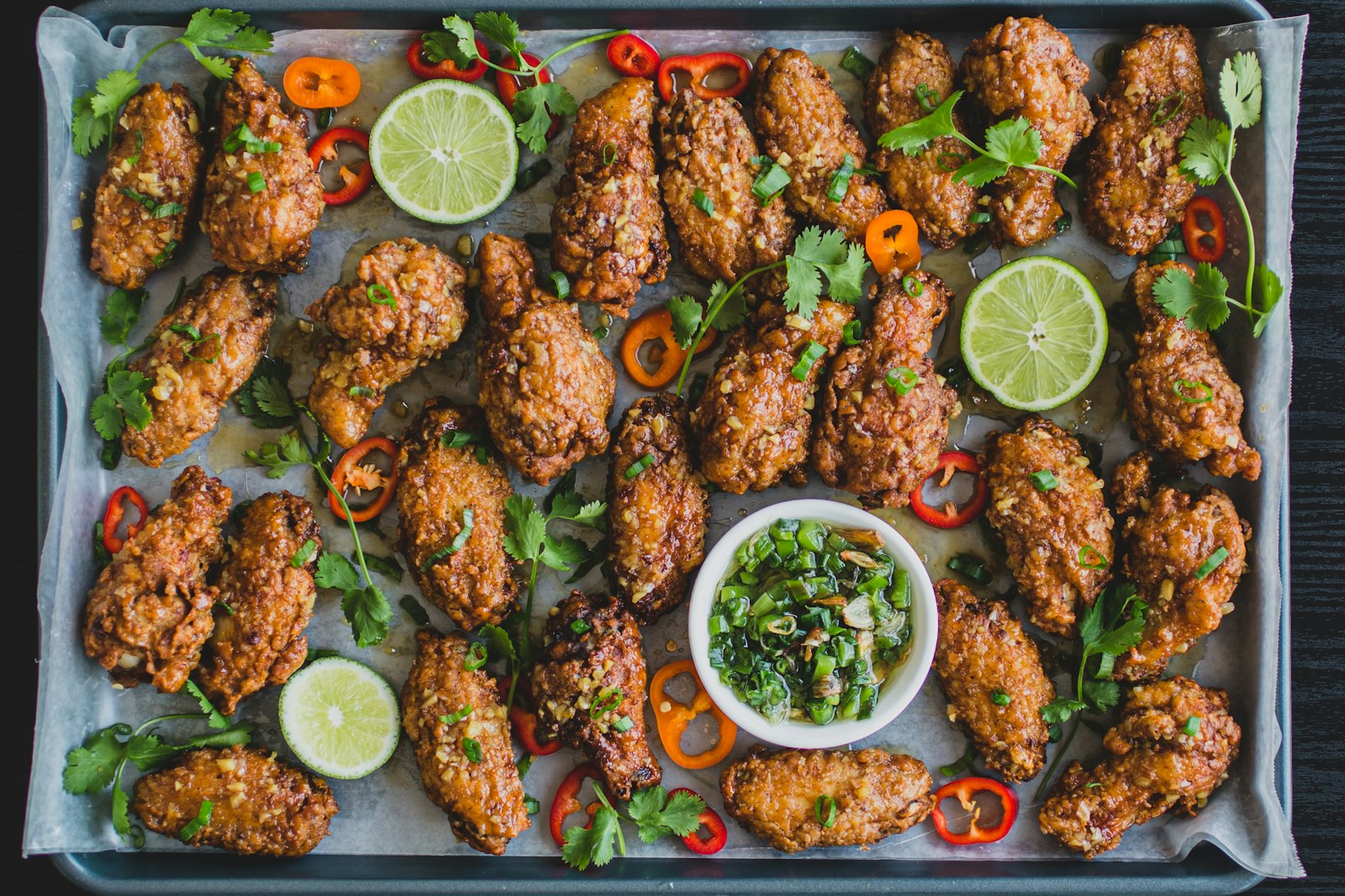 Roast chicken and vegetables on a black sheet pan straight from the oven