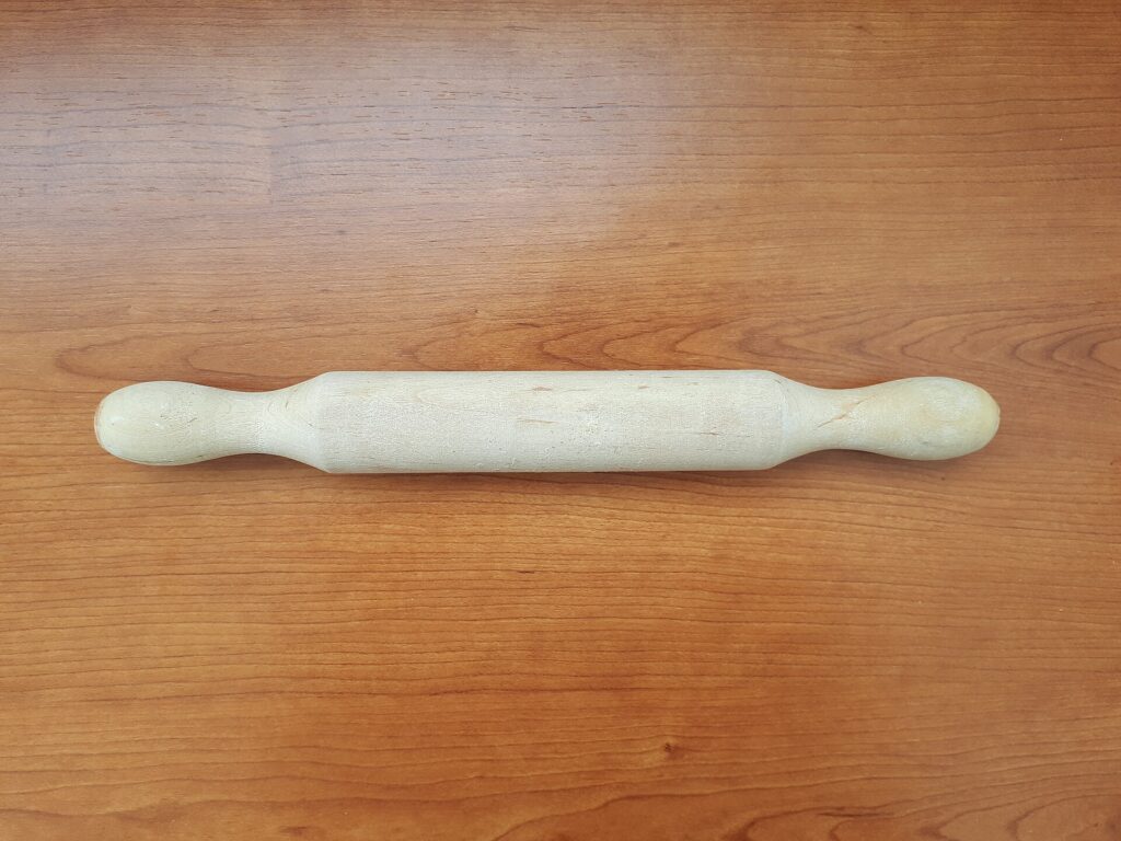 Measuring spoons holding flour and sugar on a counter next to a small mixing bowl