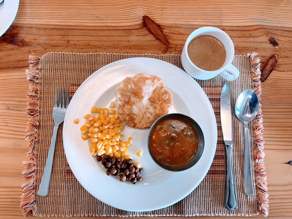Golden roasted chickpeas piled in a small bowl beside a spice jar