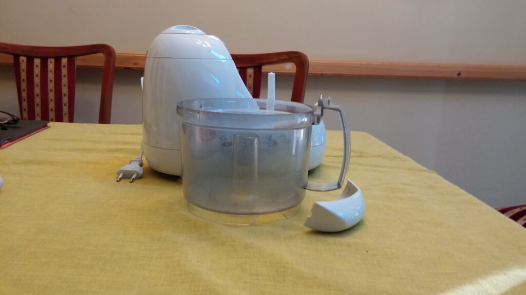 A food processor bowl on a counter with soft white cheese scraped down the sides
