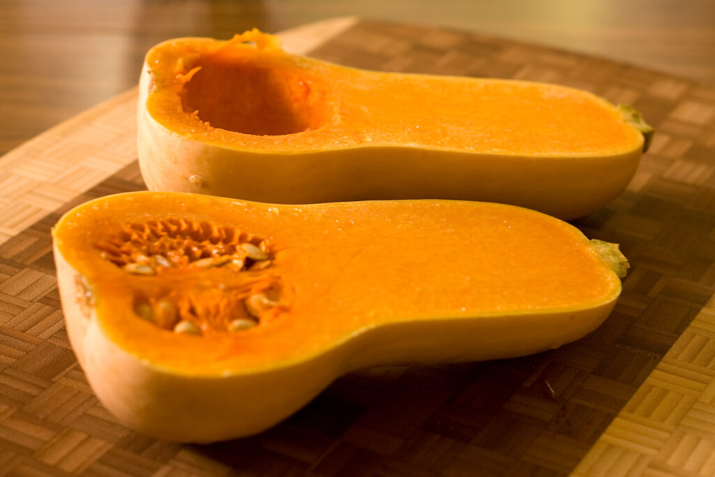 Cleaned squash seeds drying on a cloth towel beside a spoon and a small bowl