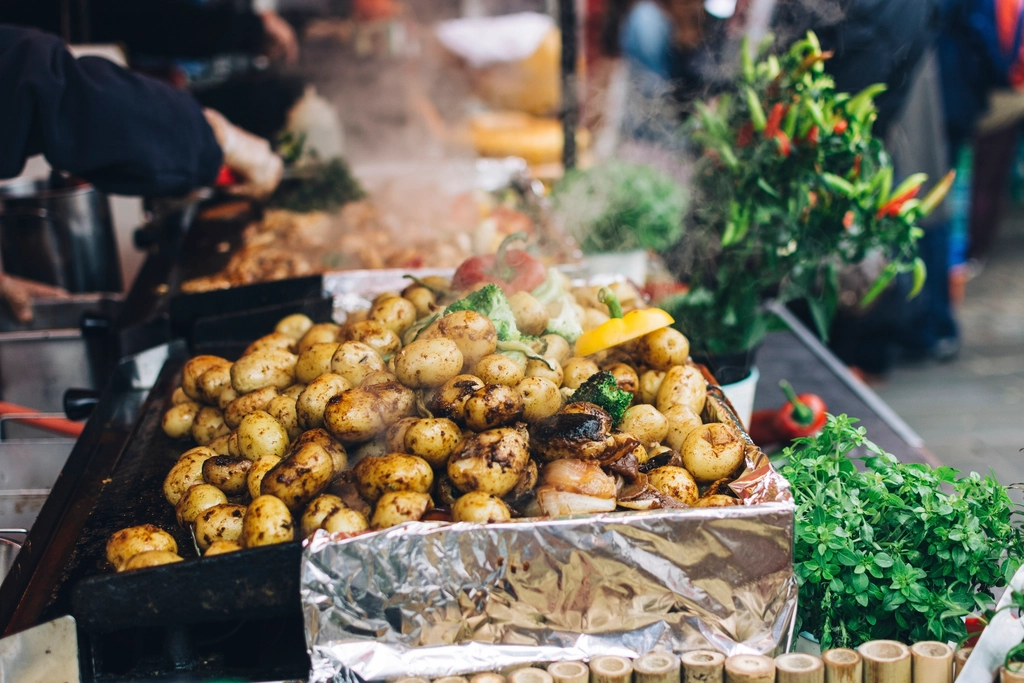 Halved baby potatoes and broccoli roasting in a single layer on a metal sheet pan
