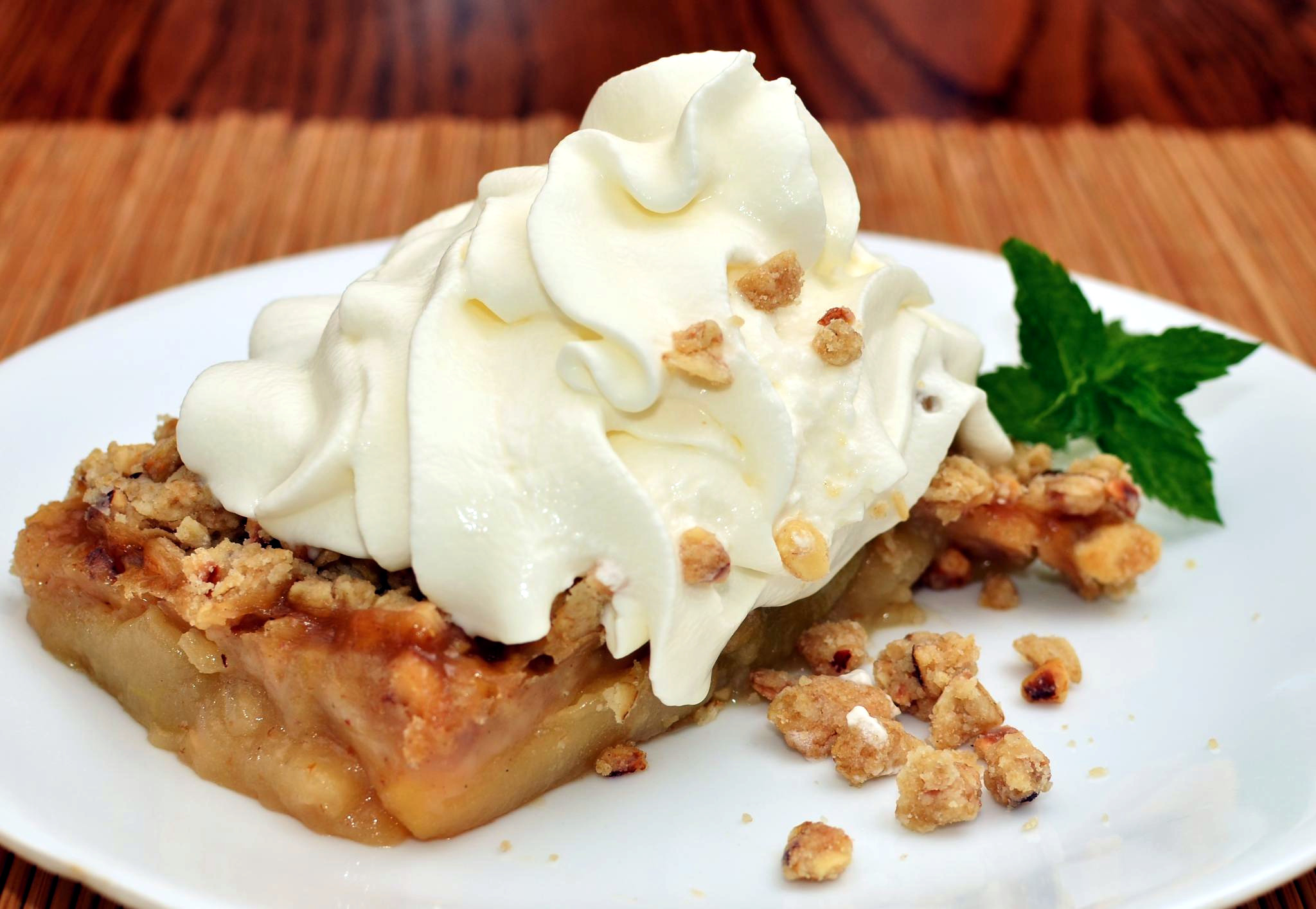 A baked fruit crisp in a square dish with a browned oat crumb topping