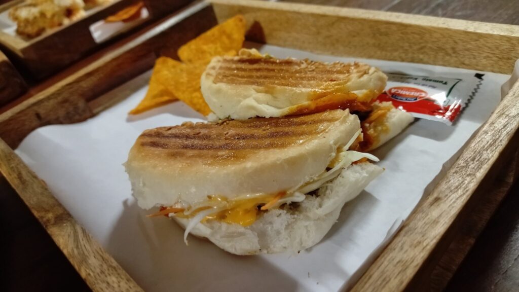 Tortilla chips spread across a pan and covered evenly with shredded cheese before broiling