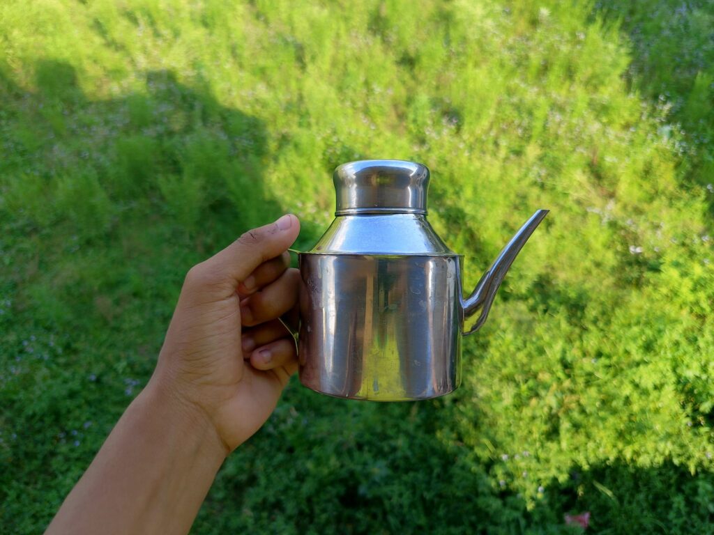 A large stainless pot standing in a sink of cold water and ice to cool quickly