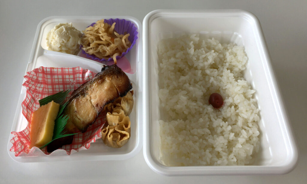 A spoonful of smooth light brown fermented paste lifted from a refrigerated tub