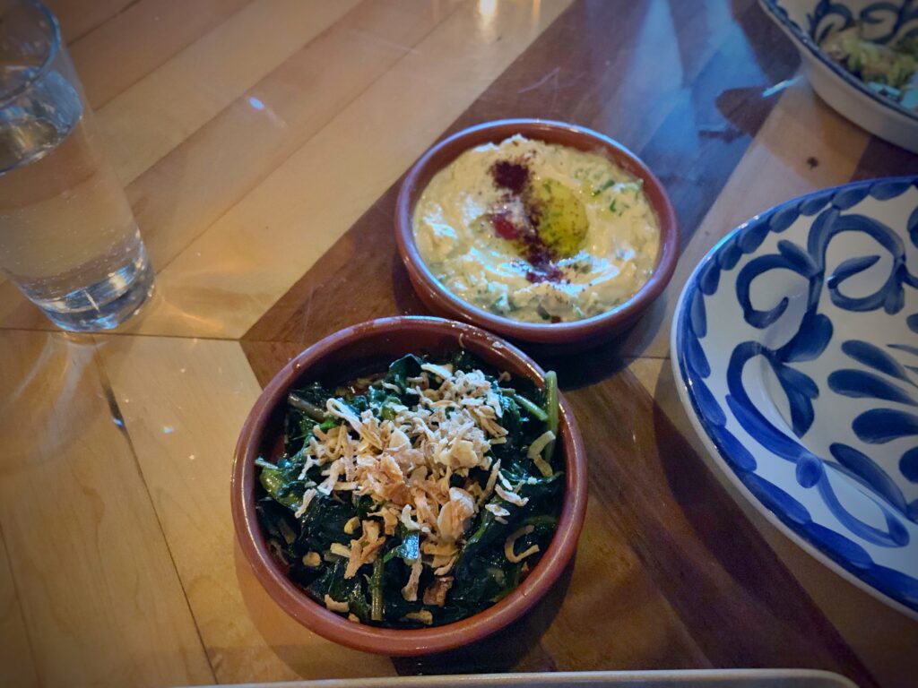 A small bowl of crispy golden fried shallots and garlic bits on a wooden table