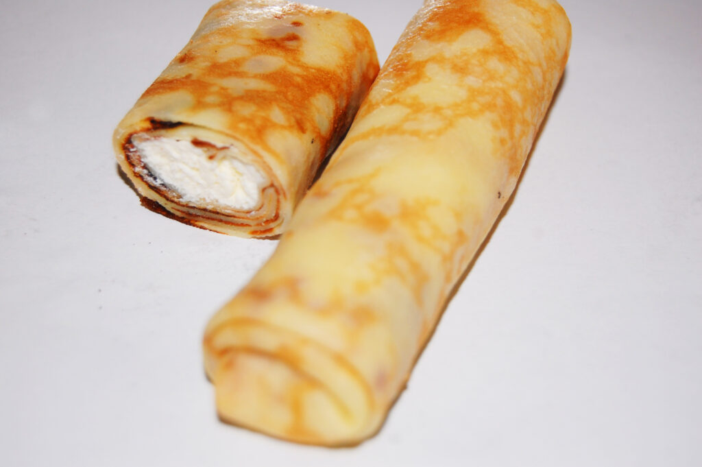 A small bowl of cottage cheese dusted with cinnamon next to sliced apple